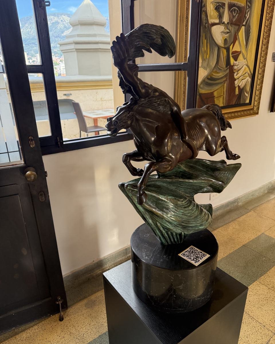 Palacio Nacional, Medellín. A room in the gallery: a bronze horse on a black plinth, paintings on the wall and the door open to the terrace.